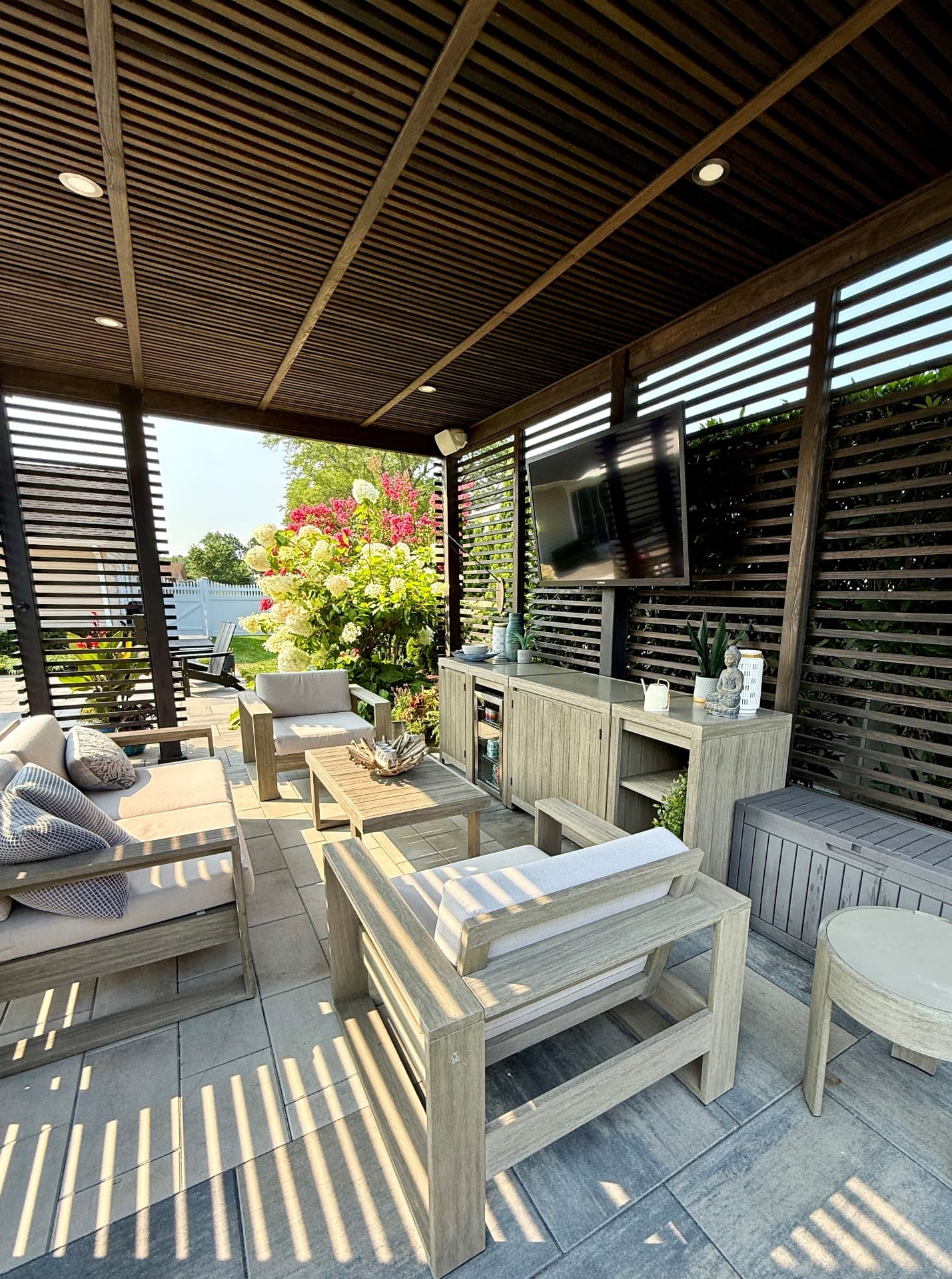 Covered outdoor living area with pavers, an outdoor kitchen and dining space, specialty paver services by Empire Pavers in Utah