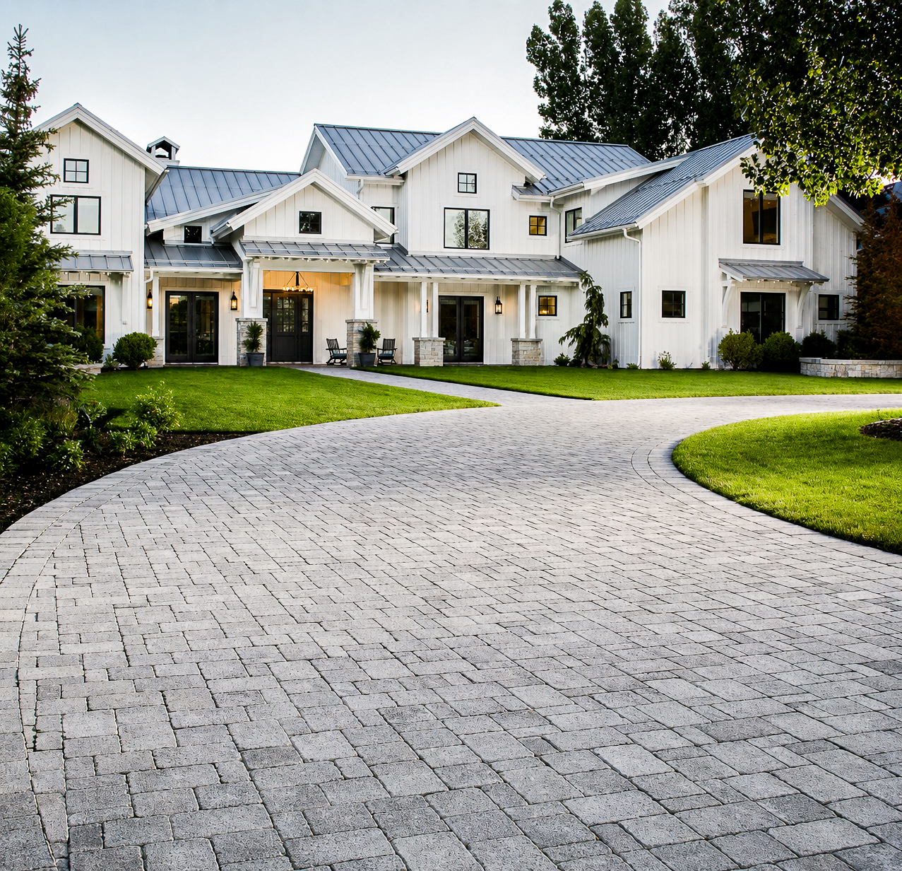 Grey paver driveway curving up to a white modern farmhouse in Utah, commercial paver installation by Empire Pavers in Utah